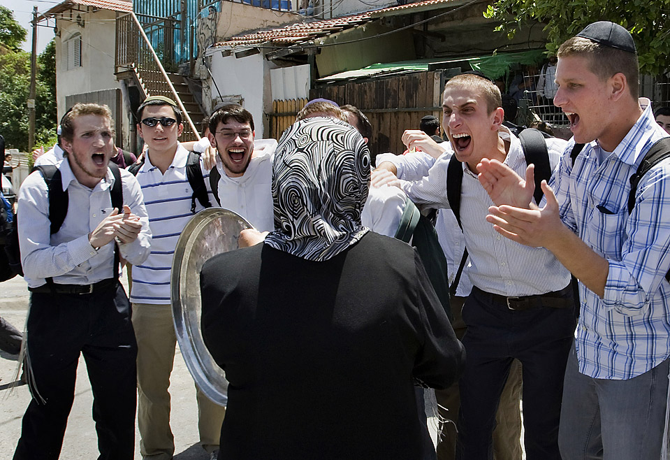 Israeli youths jeer at a Palestinian woman in Sheikh Jarra neighbourhood of Jerusalem who has just been made homeless by settlers