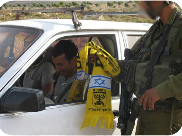 “Slaves for the Jews...our friend from the stands in a typical picture at one of the roadblocks, ‘Kiss the scarf and then you pass'.