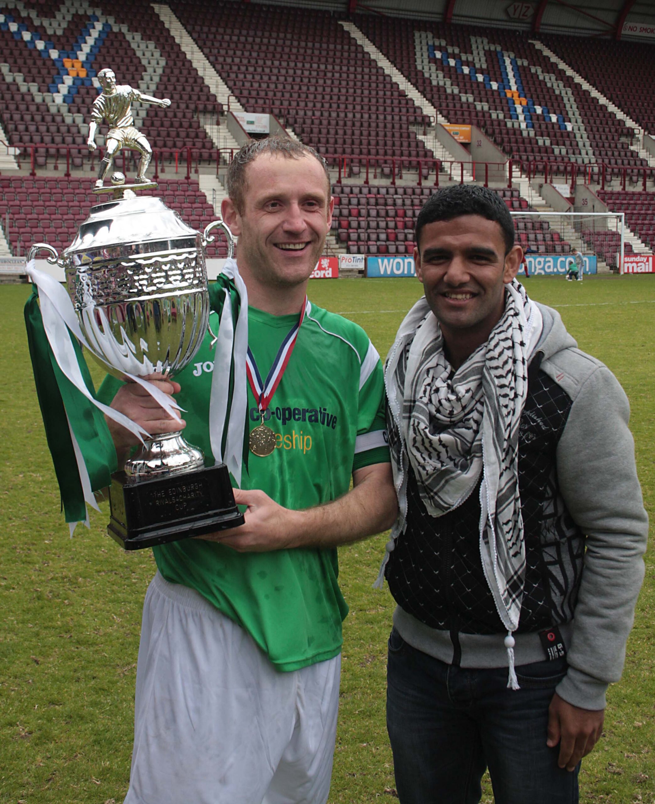 Palestinian footballer Mahmoud Sarsak presenting the Rivals4Charity trophy to  Hibs Skipper Frankie Arthur