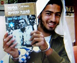The killer, Eden Natan-Zada, poses with a book by late Rabbi Meir Kahane