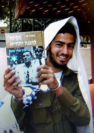 The killer, Eden Natan-Zada, poses with a book by late Rabbi Meir Kahane